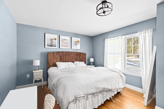 bedroom featuring baseboards and wood finished floors