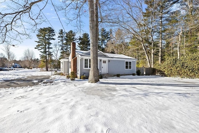 view of front of house featuring a chimney and fence