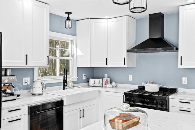 kitchen featuring light stone countertops, range, white cabinets, wall chimney exhaust hood, and a sink