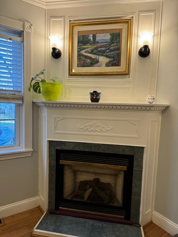 interior details with hardwood / wood-style floors, crown molding, and a fireplace