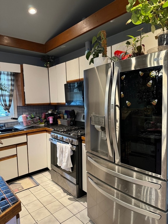 kitchen featuring white cabinets, light tile patterned floors, and appliances with stainless steel finishes