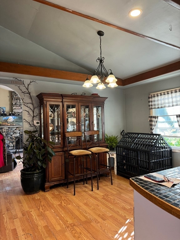 dining room with a chandelier, light hardwood / wood-style floors, and vaulted ceiling