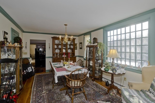 dining room with wood-type flooring, a notable chandelier, and crown molding