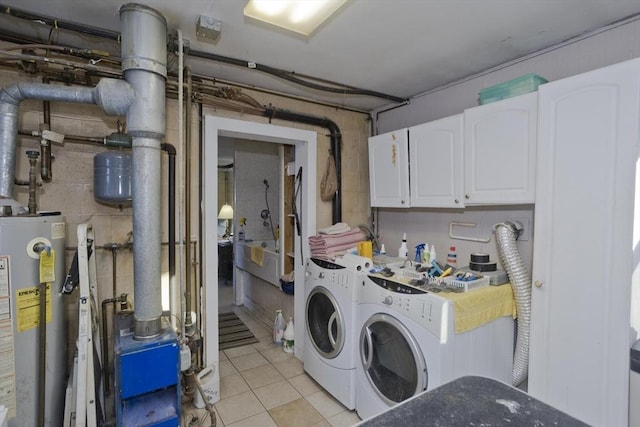 washroom featuring cabinets, light tile patterned floors, independent washer and dryer, and water heater