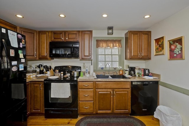 kitchen featuring light wood-type flooring, sink, and black appliances