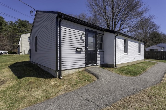 view of front of home featuring fence and a front lawn