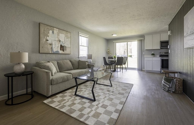 living area with a textured ceiling, a textured wall, and wood finished floors