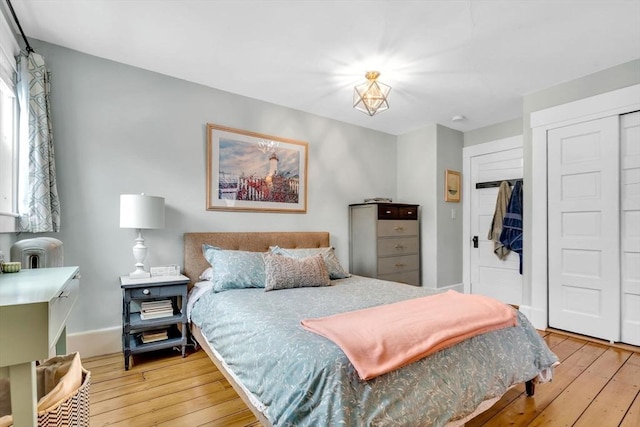 bedroom with a closet, baseboards, and hardwood / wood-style flooring