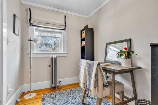 office space featuring crown molding, radiator, wood finished floors, and baseboards