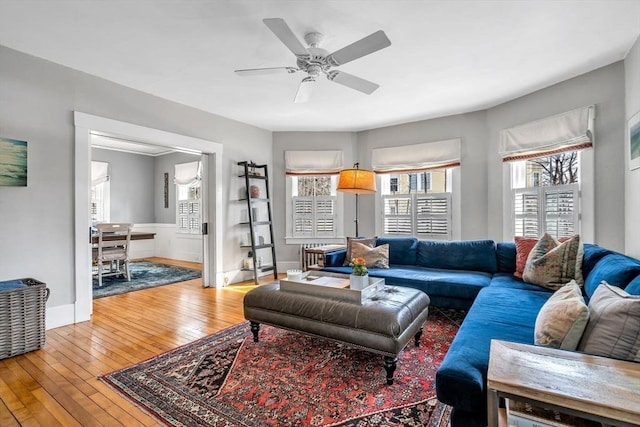 living area with hardwood / wood-style floors, baseboards, and ceiling fan