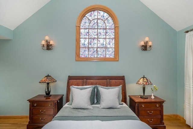 bedroom with vaulted ceiling and light hardwood / wood-style floors