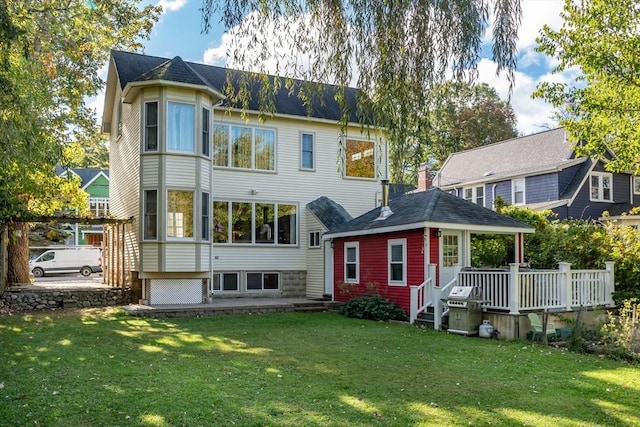 back of house with a wooden deck and a yard