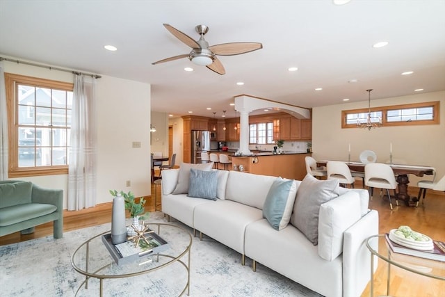 living room with ceiling fan, ornate columns, and light hardwood / wood-style flooring