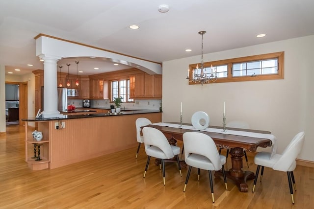 dining space featuring ornate columns and light hardwood / wood-style floors