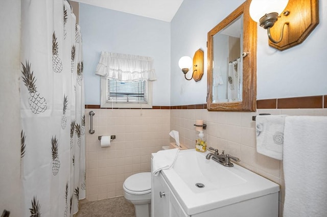 full bath with tile walls, tile patterned flooring, a wainscoted wall, vanity, and toilet