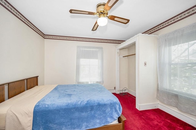 carpeted bedroom featuring baseboards, a ceiling fan, and multiple windows