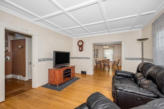 living room with coffered ceiling, light wood finished floors, and visible vents