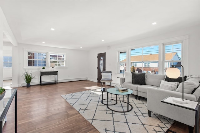 living room featuring hardwood / wood-style floors, plenty of natural light, and a baseboard heating unit