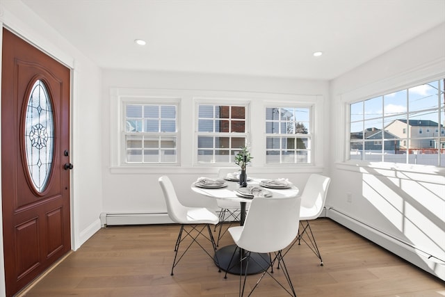 dining area featuring light wood-type flooring and a baseboard heating unit