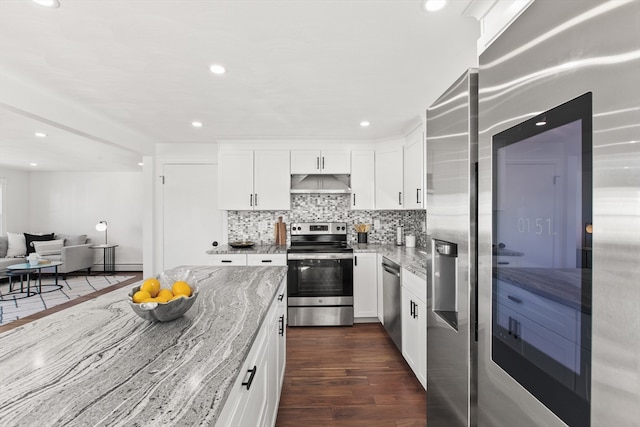 kitchen featuring light stone countertops, dark hardwood / wood-style floors, backsplash, white cabinets, and appliances with stainless steel finishes