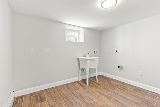 laundry room featuring hookup for an electric dryer, washer hookup, light hardwood / wood-style flooring, and a baseboard heating unit