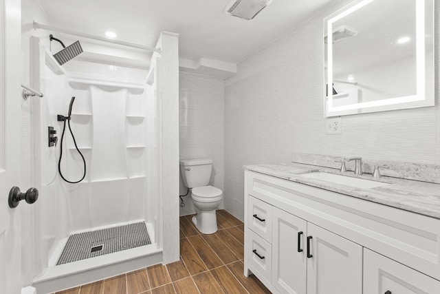 bathroom featuring vanity, toilet, and a shower