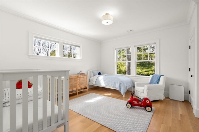 32 S Woodside Ave, Wellesley, MA 02482 - bedroom featuring multiple windows, ornamental molding, and light wood-style flooring