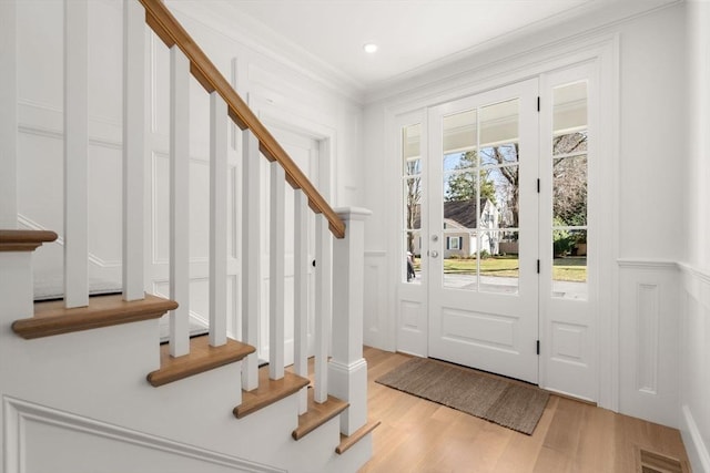 32 S Woodside Ave, Wellesley, MA 02482 - entryway featuring stairs, ornamental molding, light wood-style floors, and a decorative wall