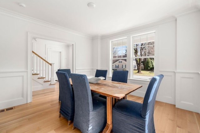 32 S Woodside Ave, Wellesley, MA 02482 - dining room with a decorative wall, light wood finished floors, stairs, crown molding, and wainscoting