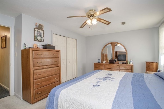 carpeted bedroom with ceiling fan and a closet