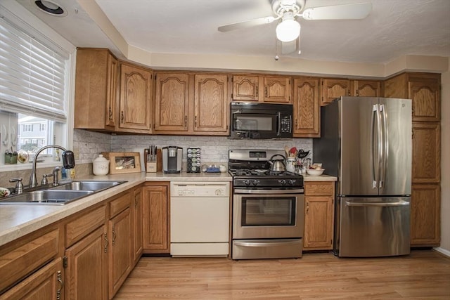 kitchen featuring stainless steel appliances, light hardwood / wood-style floors, sink, and decorative backsplash