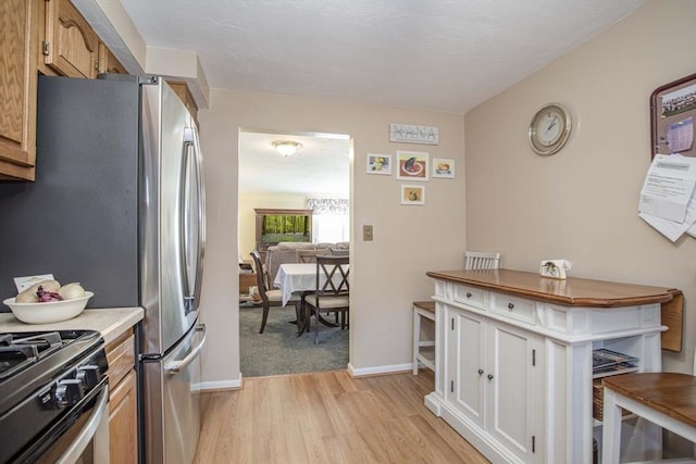 kitchen featuring stainless steel fridge and light hardwood / wood-style floors