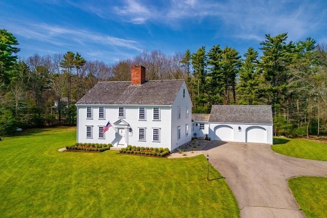 view of front of home featuring an outdoor structure, a front lawn, and a chimney