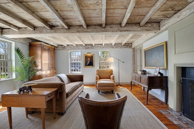 sitting room featuring light wood-style floors, a wealth of natural light, and beamed ceiling