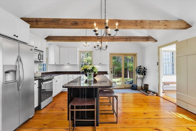 kitchen with white cabinetry, lofted ceiling with beams, light wood-style flooring, a notable chandelier, and stainless steel appliances