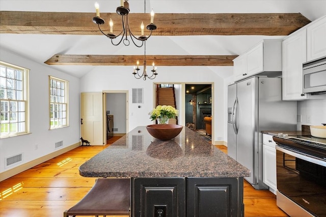 kitchen with stainless steel appliances, a chandelier, lofted ceiling with beams, and visible vents