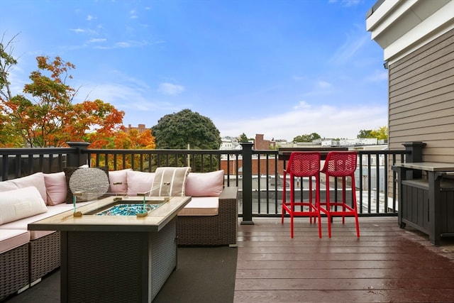 deck featuring an outdoor living space with a fire pit