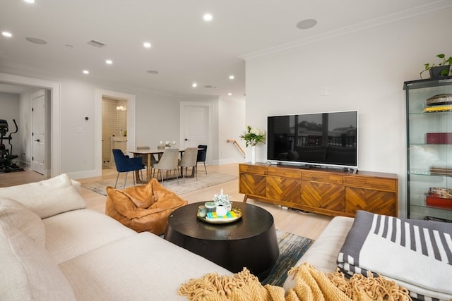 living room featuring light wood-type flooring and crown molding