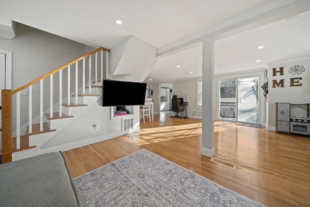 unfurnished living room with wood-type flooring and crown molding