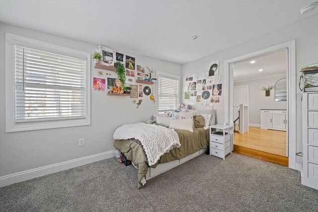 bedroom with carpet floors and multiple windows