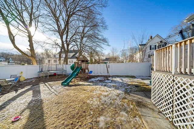 view of yard with a trampoline and a playground