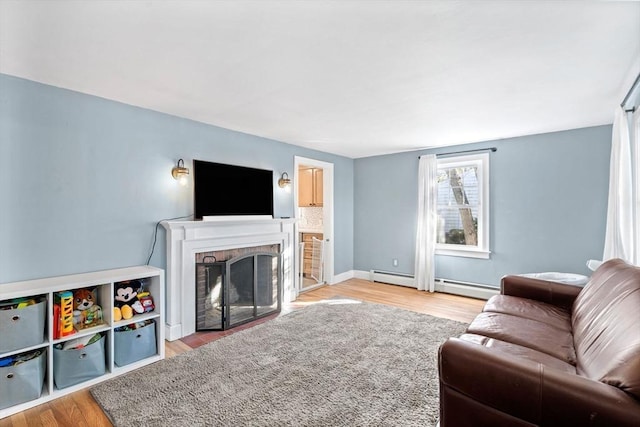 12 Babson St, Wakefield, MA 01880 - living area with light wood-style floors, baseboard heating, and a brick fireplace