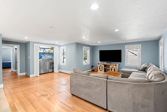 12 Babson St, Wakefield, MA 01880 - living area featuring independent washer and dryer, recessed lighting, light wood-style floors, and a baseboard radiator