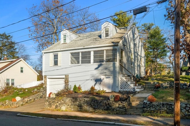 12 Babson St, Wakefield, MA 01880 - view of home's exterior featuring stairway, a garage, and driveway