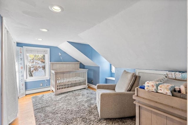 12 Babson St, Wakefield, MA 01880 - bedroom featuring a baseboard heating unit, wood finished floors, vaulted ceiling, recessed lighting, and a nursery area