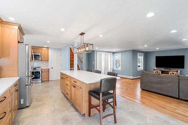12 Babson St, Wakefield, MA 01880 - kitchen with appliances with stainless steel finishes, recessed lighting, a center island, a kitchen bar, and open floor plan