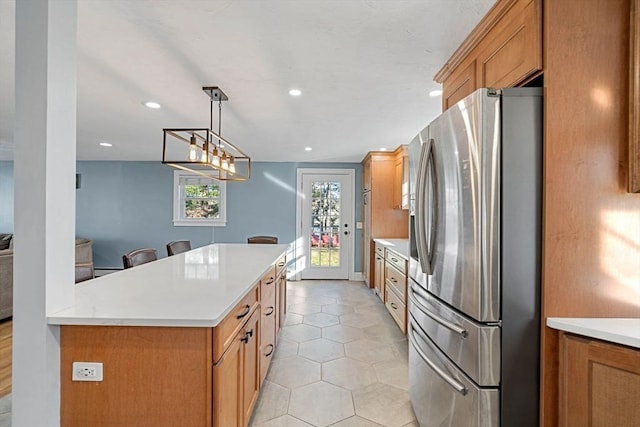 12 Babson St, Wakefield, MA 01880 - kitchen with stainless steel fridge, light countertops, light tile patterned floors, brown cabinets, and recessed lighting