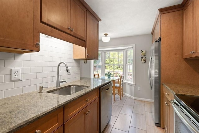 25 Valiant Way Unit 25, Salem, MA 01970 - kitchen with stainless steel appliances, a sink, brown cabinets, and decorative backsplash