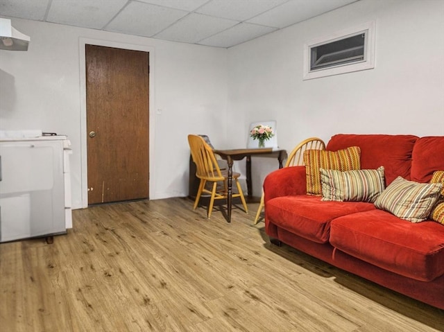 living area with wood finished floors and a paneled ceiling