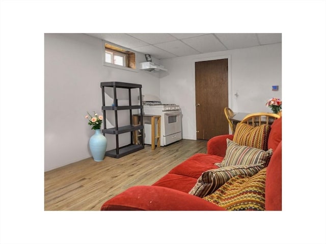 living room with wood finished floors and a paneled ceiling